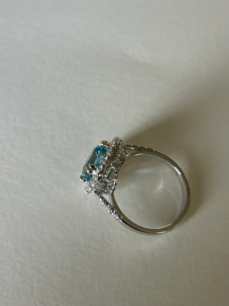 Cushion cut aquamarine & diamond cluster ring, in 18ct white gold, with contrasting yellow gold claws.  Side view, showing a pretty white gold setting.