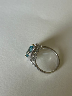 Cushion cut aquamarine & diamond cluster ring, in 18ct white gold, with contrasting yellow gold claws.  Side view, showing a pretty white gold setting.